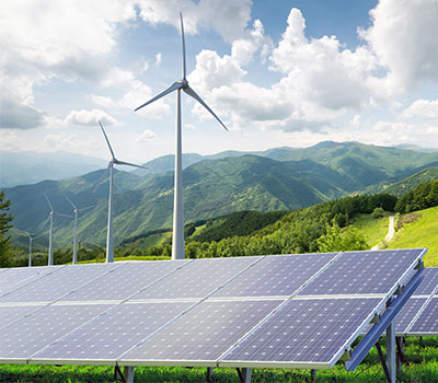 energy production - a mountainside with wind turbine and solar panels