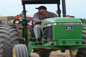 Farmer on tractor using rural site for children's tractor rides